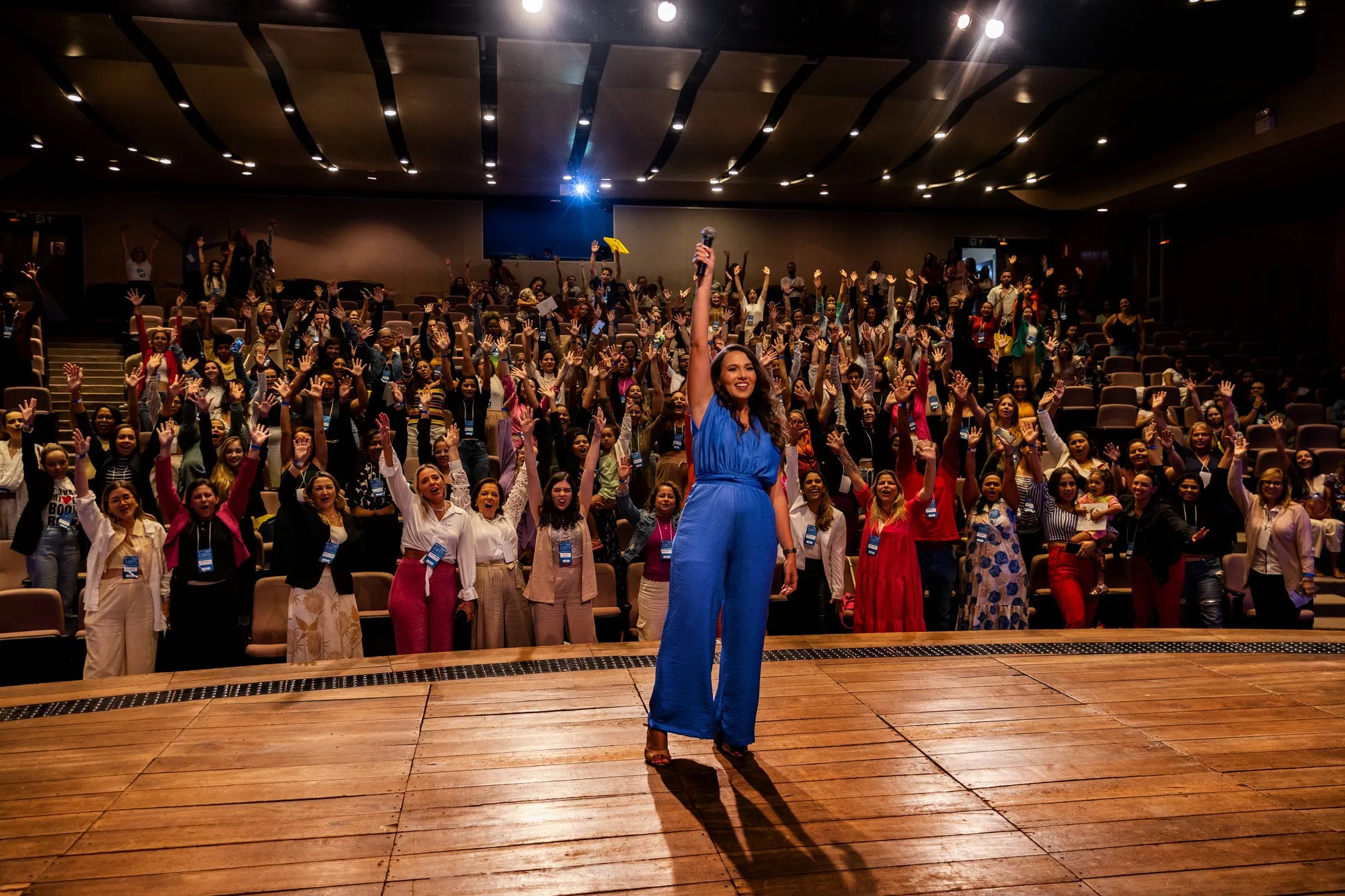 Tati no palco do ENFFA com a plateia de braços levantados
